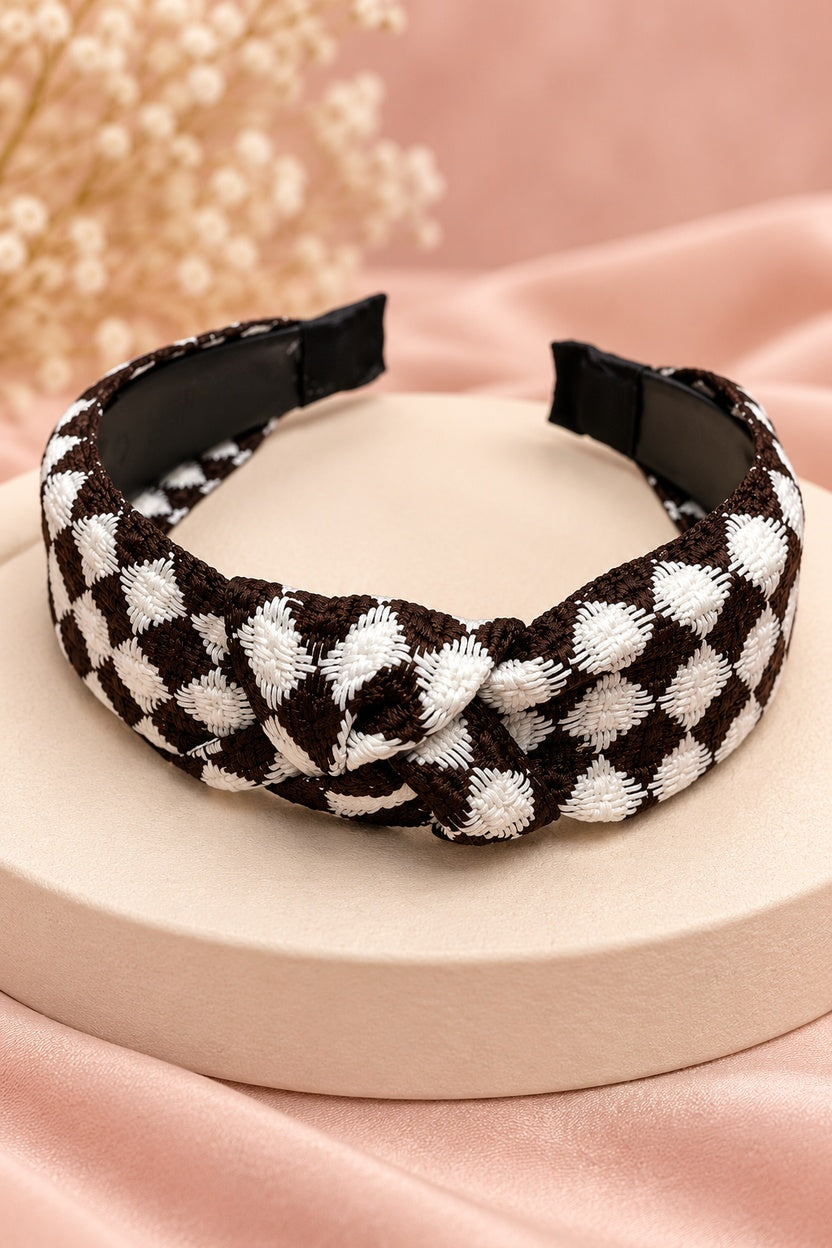 Close-up of brown and white checkered headband texture, top knot and black covered end tips