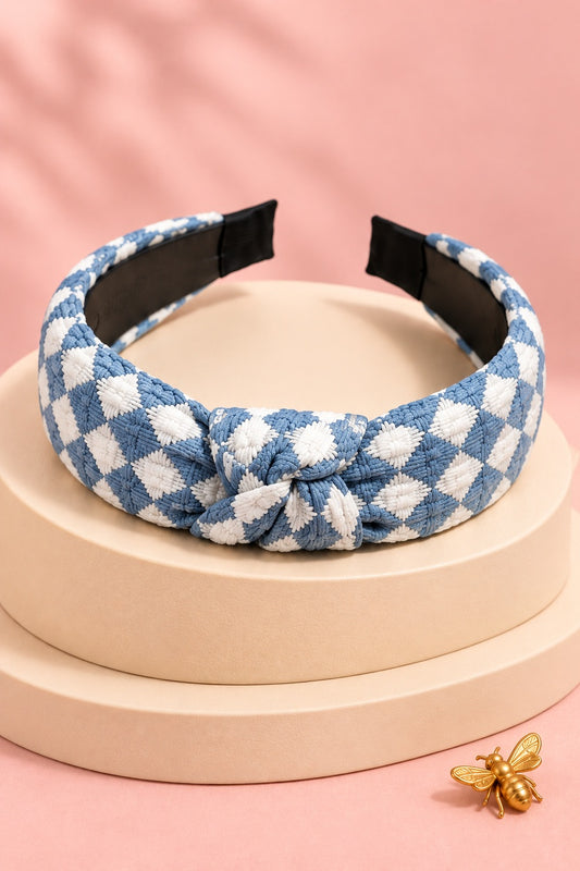 Blue checkered top-knot headband with white checks on a boutique display