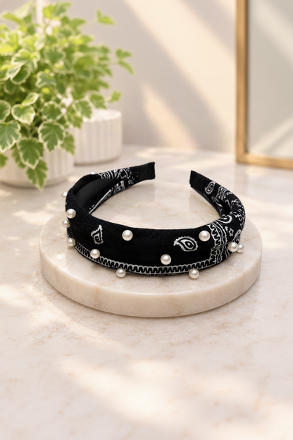 Black pearl-embellished bandana headband on cream marble boutique display