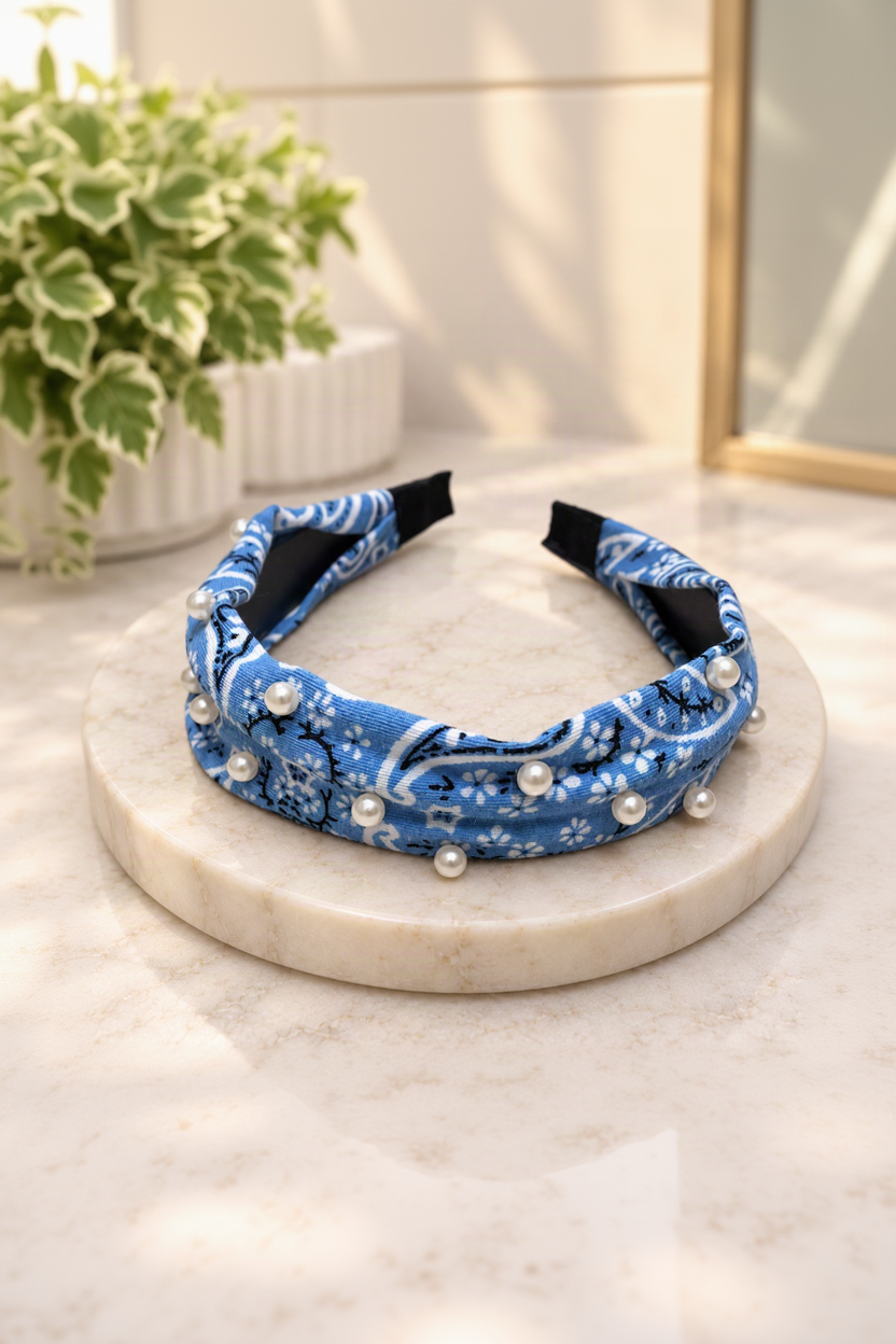 light-blue pearl-embellished bandana headband on cream marble boutique display