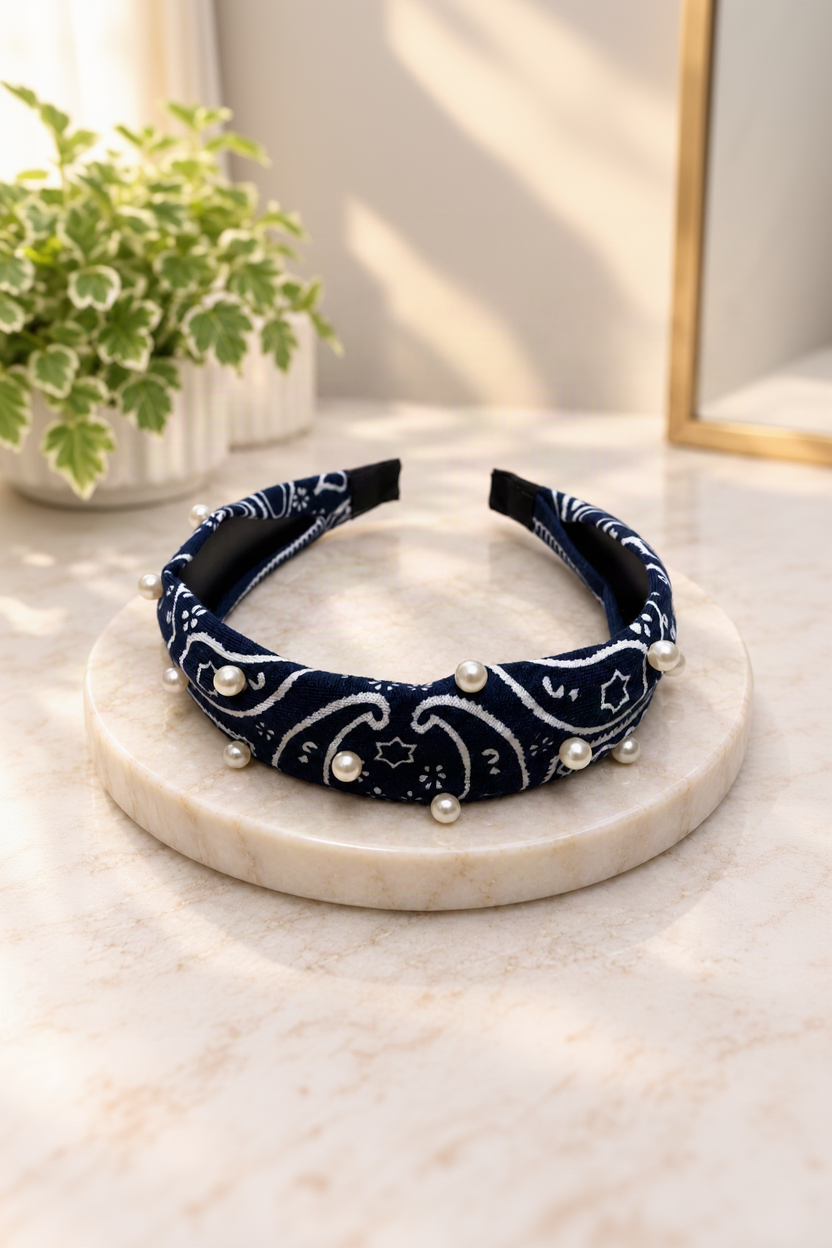 Navy pearl-embellished bandana headband on cream marble boutique display
