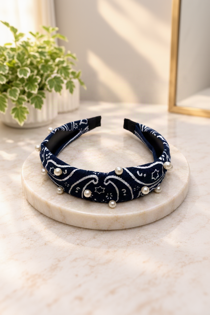 Navy pearl-embellished bandana headband on cream marble boutique display