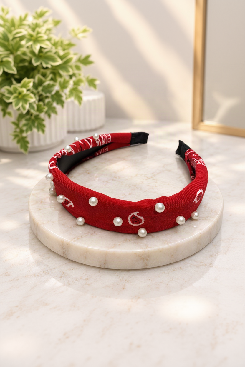 red pearl-embellished bandana headband on cream marble boutique display