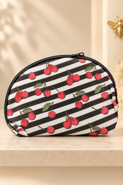 Black and white stripes, red illustrated cherries and green leaves; black zipper and piping cherry-print makeup bag. One selected bag per purchase.