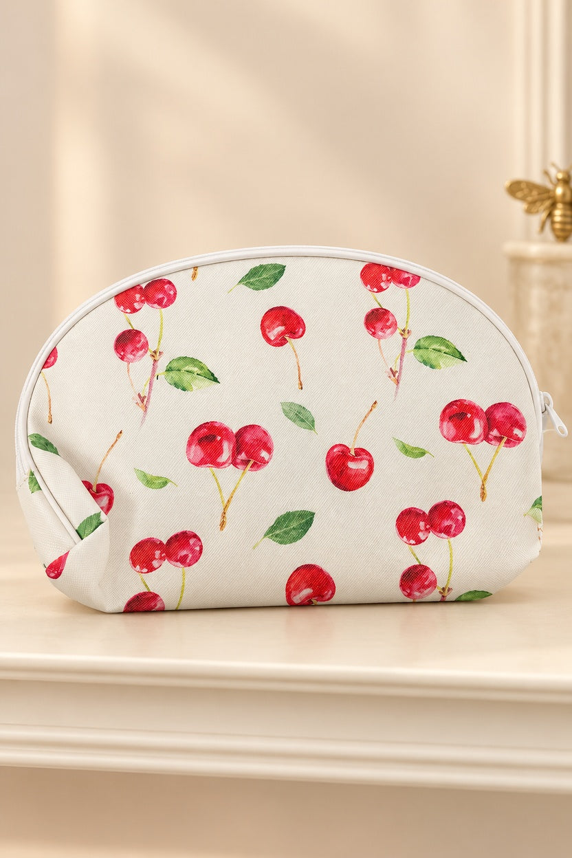 White makeup bag with watercolor-style red cherries and green leaves, white zipper and piping. One selected bag per purchase.