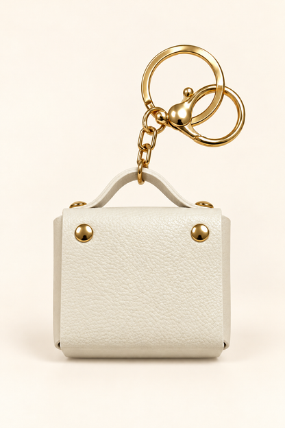 White mini coin purse keychain with gold-tone hardware
