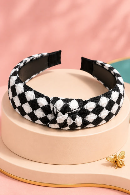 Black checkered top-knot headband with white checks on a boutique display