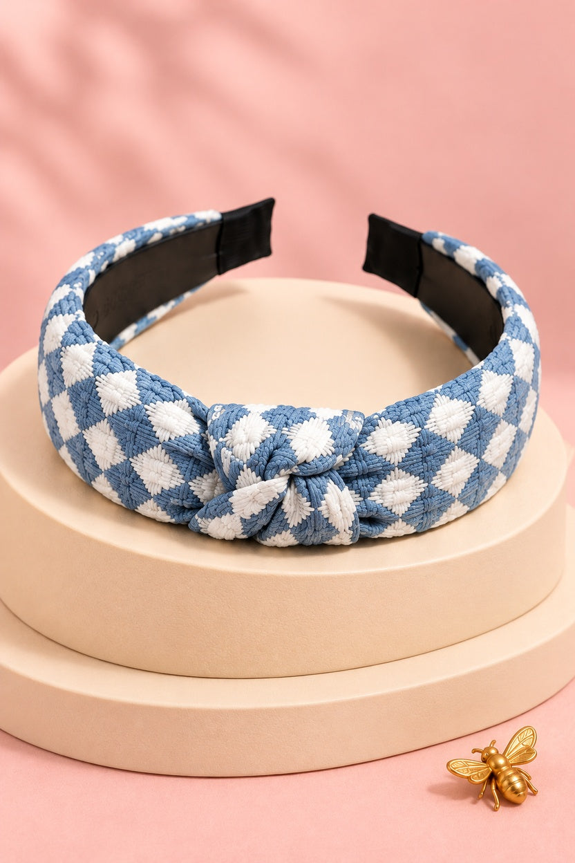 Blue checkered top-knot headband with white checks on a boutique display
