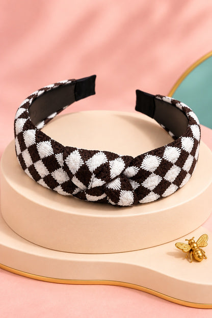 Brown checkered top-knot headband with white checks on a boutique display