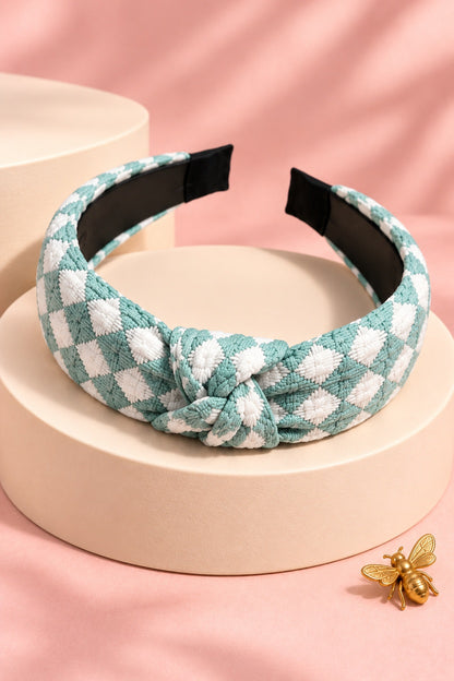 Mint Green checkered top-knot headband with white checks on a boutique display