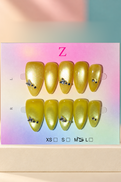 Yellow Gold Shimmer Jeweled Press-On / Glue-On Nails – Almond Size M; original manufacturer card displayed without outer wrapper on a cream studio plinth