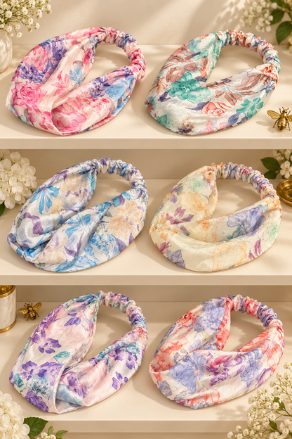 Six pastel floral scarf headbands with elastic backs on a boutique display