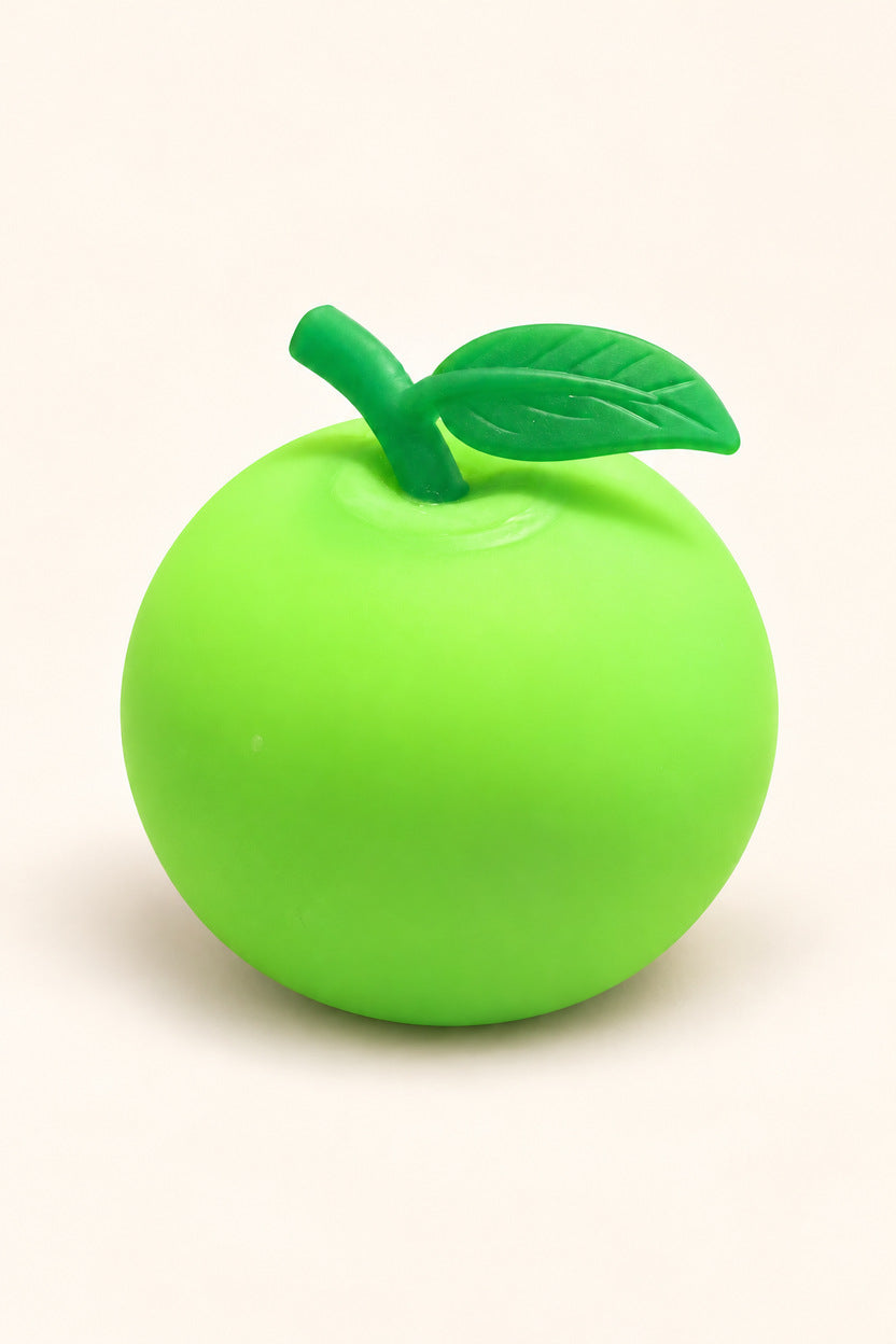 Lime green apple squishy stress toy with darker green leaf on ivory background