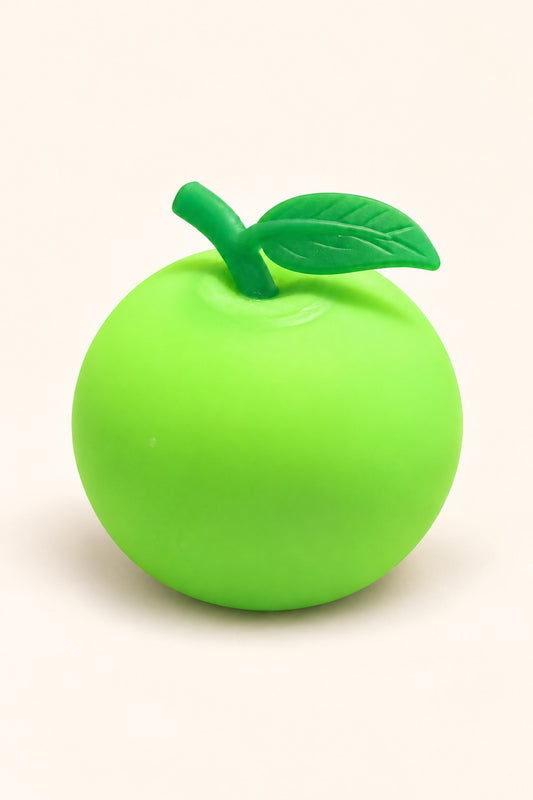 Lime green apple squishy stress toy with darker green leaf on ivory background