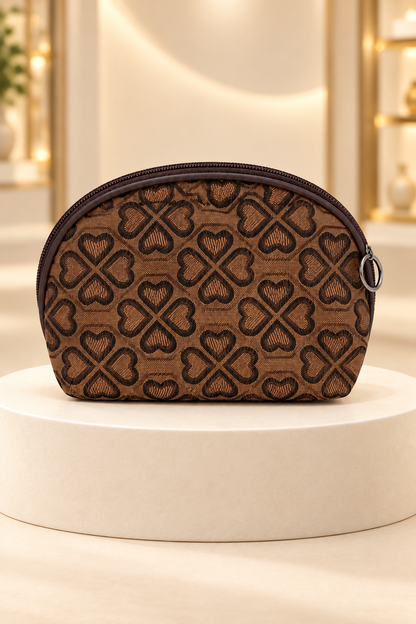 Brown heart-pattern makeup bag on a cream boutique display riser, shown unpackaged