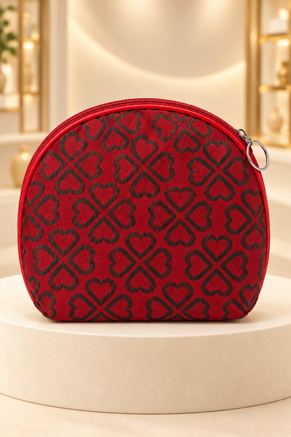 Red heart-pattern makeup bag on a cream boutique display riser, shown unpackaged