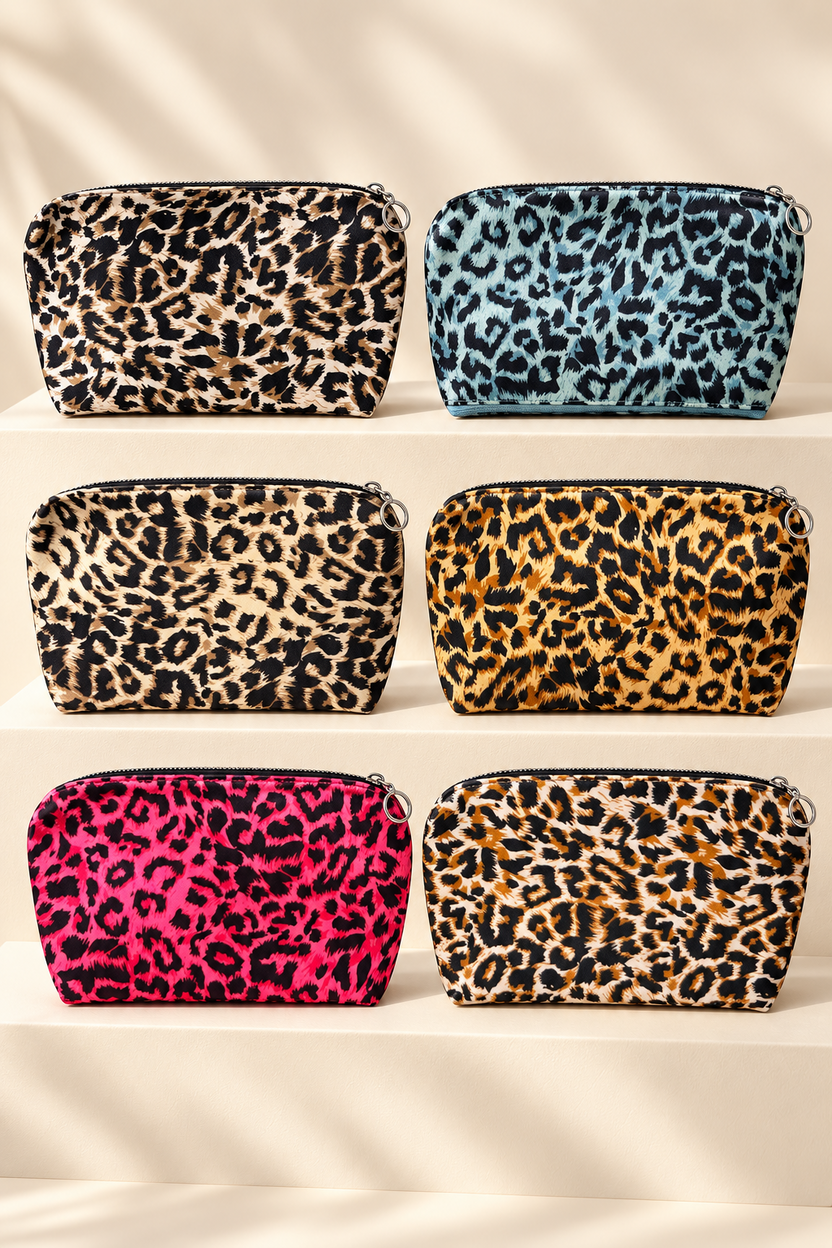 Six leopard-print makeup bag color combinations displayed unpackaged on cream boutique risers; one selected bag per purchase