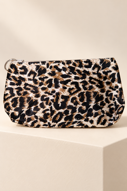 Cream/Black leopard-print makeup bag shown unpackaged on a cream boutique display riser