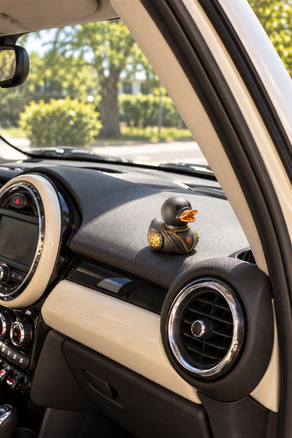 Midas novelty duck on dashboard inside parked cream MINI