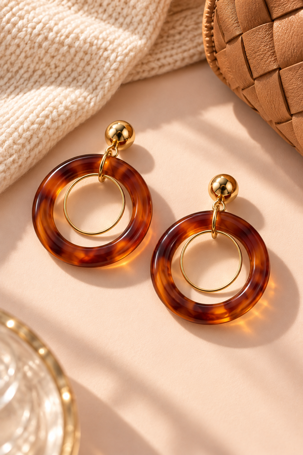 Amber Brown MINT double hoop earrings styled beside cream knitwear and a tan woven bag