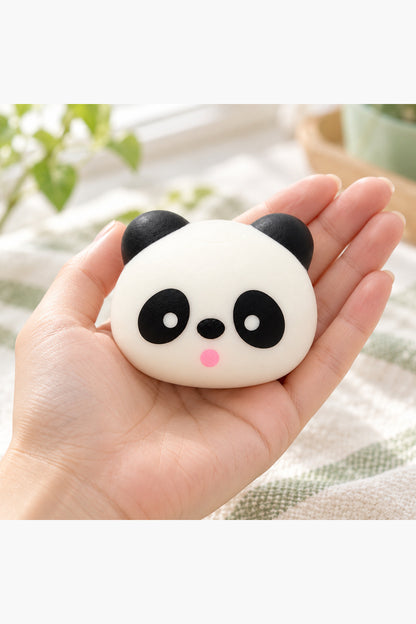 Adult hand holding the approximately three-inch panda squishy for scale