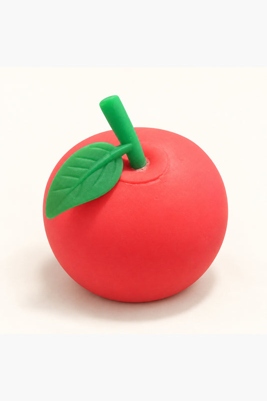 Red apple squishy stress toy with green leaf on ivory background
