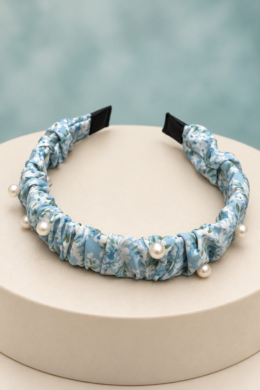 Blue ruched floral headband with pearl-style beads on a boutique display