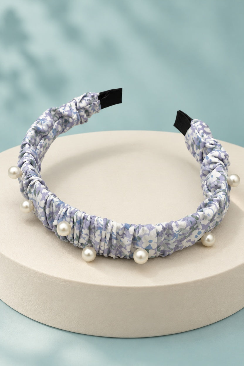 Lavender ruched floral headband with pearl-style beads on a boutique display