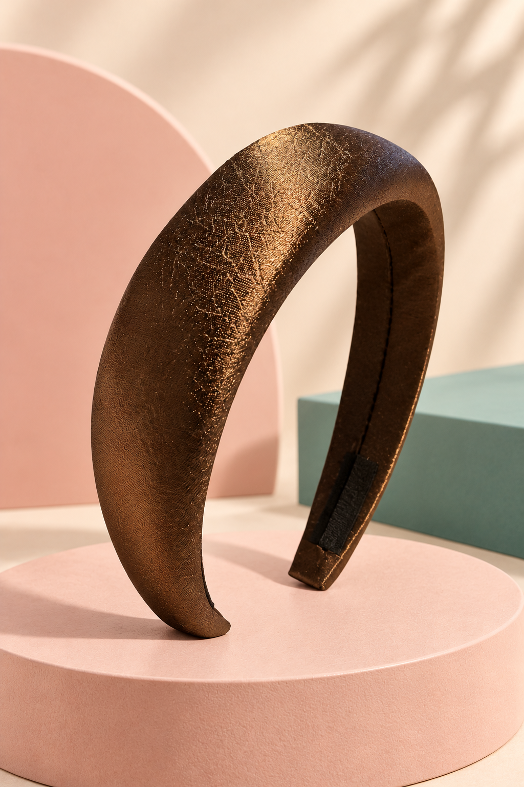 Bronze textured padded headband on a boutique display